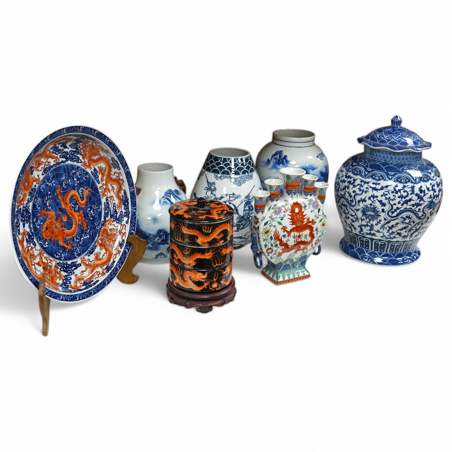 Three blue and white Chinese porcelain vases, a similar jar and cover, plus three stacking jars and covers on stand, a large dragon designed charger on stand and a similar decorated vase, charger 39cm diameter (7). Condi